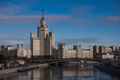 Bridge over river in city against sky