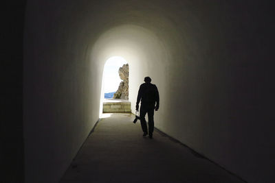 Rear view of man walking in corridor