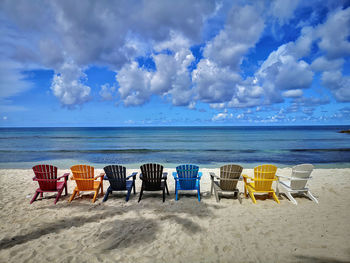 Beach chairs on the beach in aruba in different colors