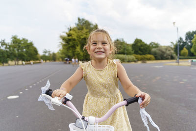 Happy girl sitting on bicycle at park