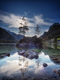 Scenic view of lake by trees against sky