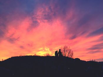 Silhouette man against orange sky