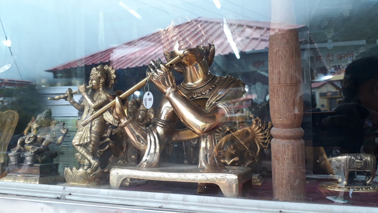 STATUE AGAINST TEMPLE SEEN THROUGH GLASS WINDOW AT CATHEDRAL