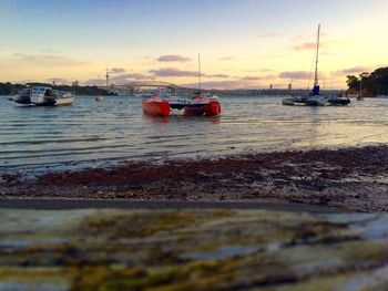 Boats in sea at sunset