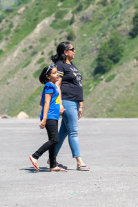 Full length of young woman walking on road
