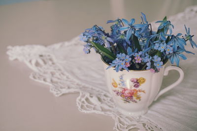 Close-up of blue flowers in cup on table