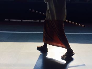 Low section of man walking on street