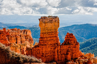 Scenic view of rocky mountains against cloudy sky