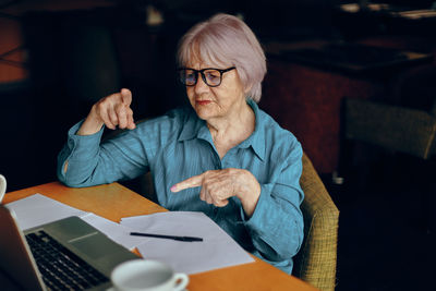 Senior woman talking on video call at cafe