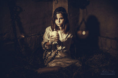 Portrait of young woman looking away at night