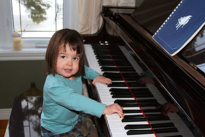 Cute girl playing piano at home