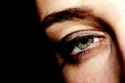 Close-up portrait of woman against black background