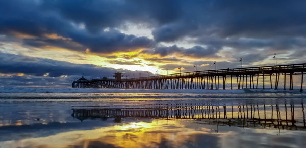 Bridge over sea against sky during sunset