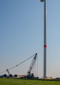 Low angle view of cranes against clear sky