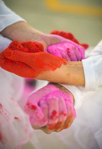 Cropped hand of people holding powder paint