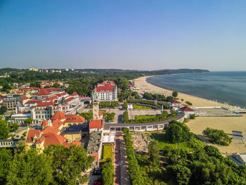 High angle view of townscape by sea against clear sky