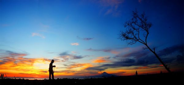 Silhouette man against orange sky during sunset