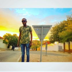 Portrait of man standing on road against sky