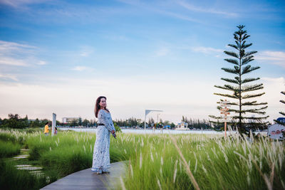 Woman standing on field against sky