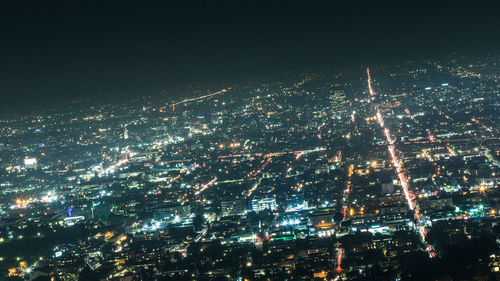 High angle view of illuminated cityscape against sky at night