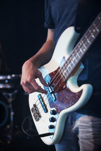 Midsection of man playing guitar