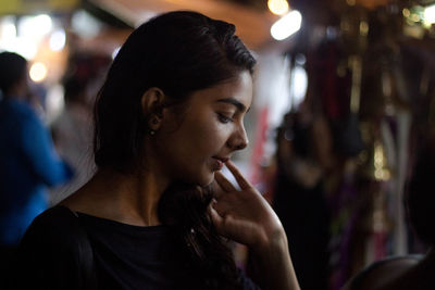 Close-up of young woman standing outdoors at night