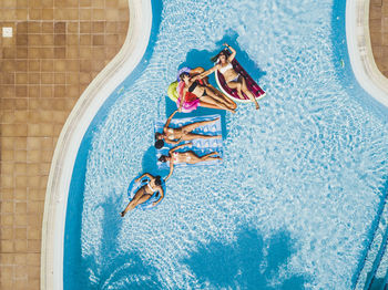 Directly above shot of people relaxing in swimming pool