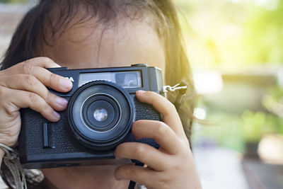 Close-up of girl photographing with camera