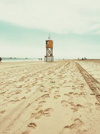 Lifeguard hut on beach against sky
