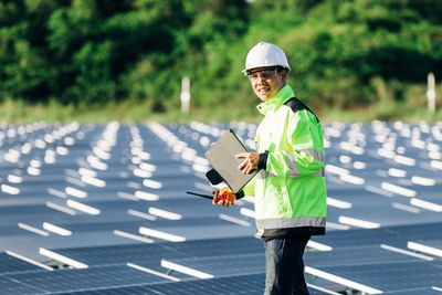 Asian engineer with digital tablet  in his hand who plans to expand the plant with solar panels. 