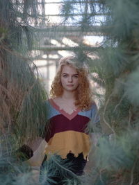 Portrait of woman standing against trees