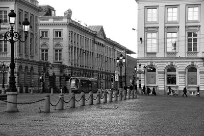 Group of people on road by buildings in city