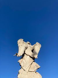 Low angle view of statue against blue sky