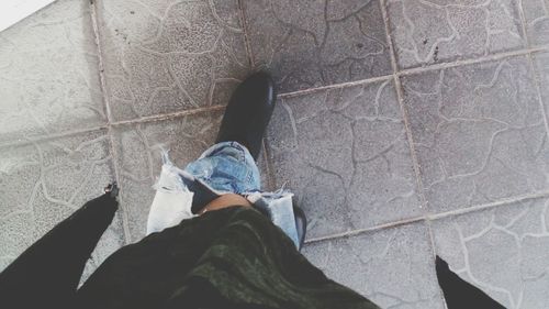 Low section of man standing on tiled floor