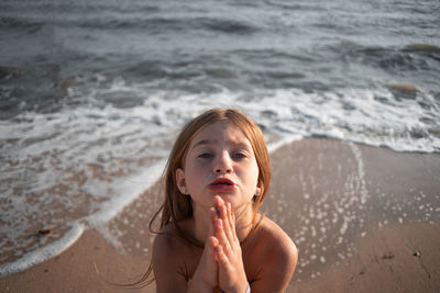 High angle portrait of cute girl standing at beach