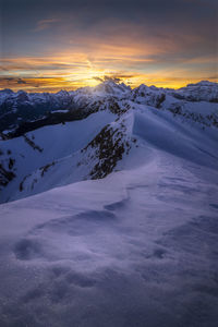 Scenic view of snowcapped mountains against sky during sunset