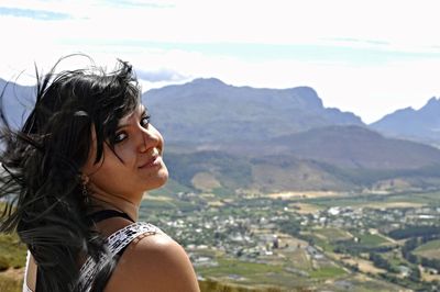 Portrait of woman standing against landscape