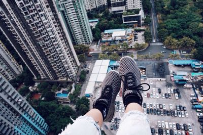 Low section of woman with skyscrapers in city