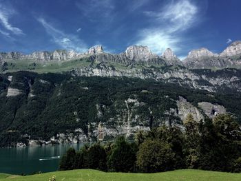 Scenic view of walensee and rocky mountains against sky