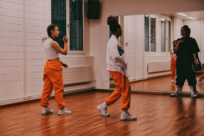 Rear view of people standing on hardwood floor