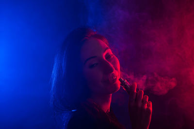 Portrait of young woman smoking cigarette