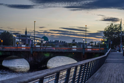 Bridge over river in city against sky