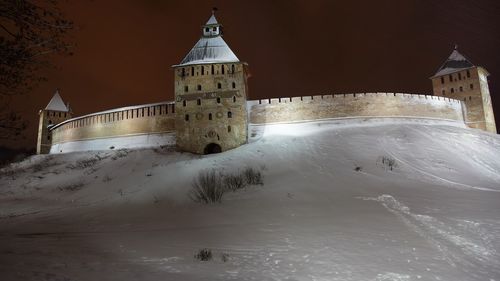 Illuminated historic building against sky during winter at night