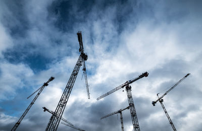 Low angle view of cranes against sky