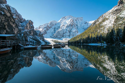 Scenic view of lake by snowcapped mountains against sky