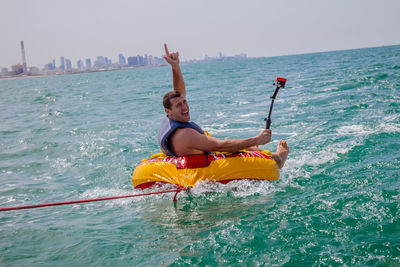 Man playing aquatic sport in sea against sky