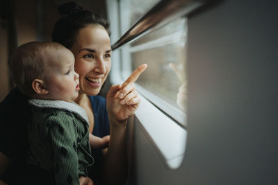 Mother with baby looking through window