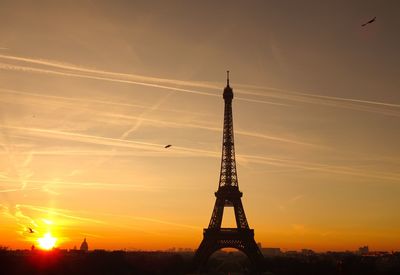 Low angle view of silhouette tower against sky during sunset