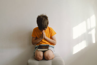 Side view of woman using mobile phone while sitting at home