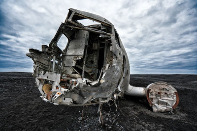 Abandoned train against cloudy sky